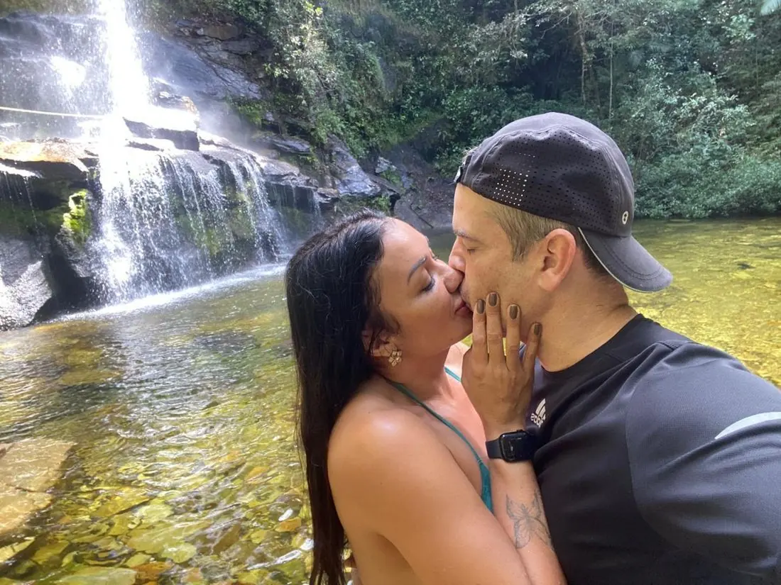 Débora e Marcelo se beijando em frente a uma cachoeira