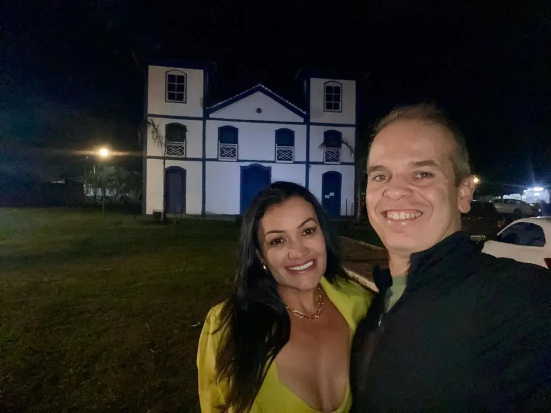 Débora e Marcelo em frente a uma igreja à noite